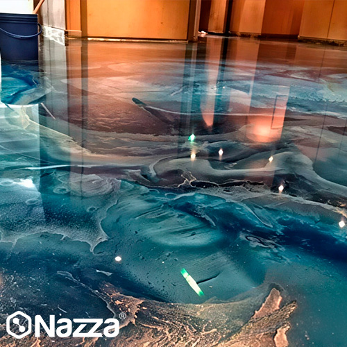 Suelo decorativo de resina epoxi con efecto artístico tipo mármol en tonos azules y turquesa. El acabado es brillante y profundo, con efecto cristal que genera sensación de volumen y gran impacto visual en interior.